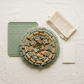 SniffRitual Calm Kit flat-lay: sage-green snuffle mat, silicone lick mat, mesh wash bag and calm ritual guide for dog enrichment